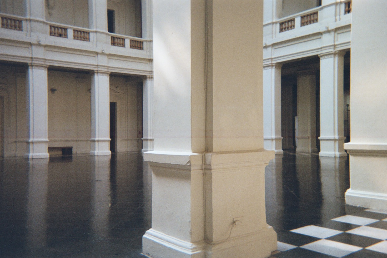 imagem analógica digitalizada do interior de um museu com saguão vazio e colunas estruturais.